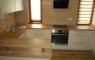 Modern konyhabútor - fehér konyhaszekrény - matt ajtófront - magasított pult, fa hatású munkapult - egyedi konyha - Renor konyhastúdió