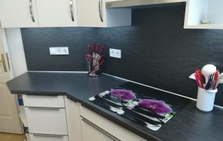 Modern konyhabútor - magasfényű fehér konyhaszekrény - sötét hátfalpanel - hosszú fogantyúk - praktikus, egyedi konyha - Renor konyhastúdió